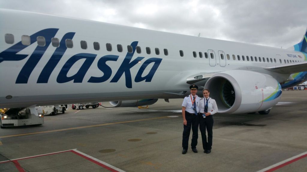 This is a photo of a father-daughter pilot team in front of an Alaska Airlines jet