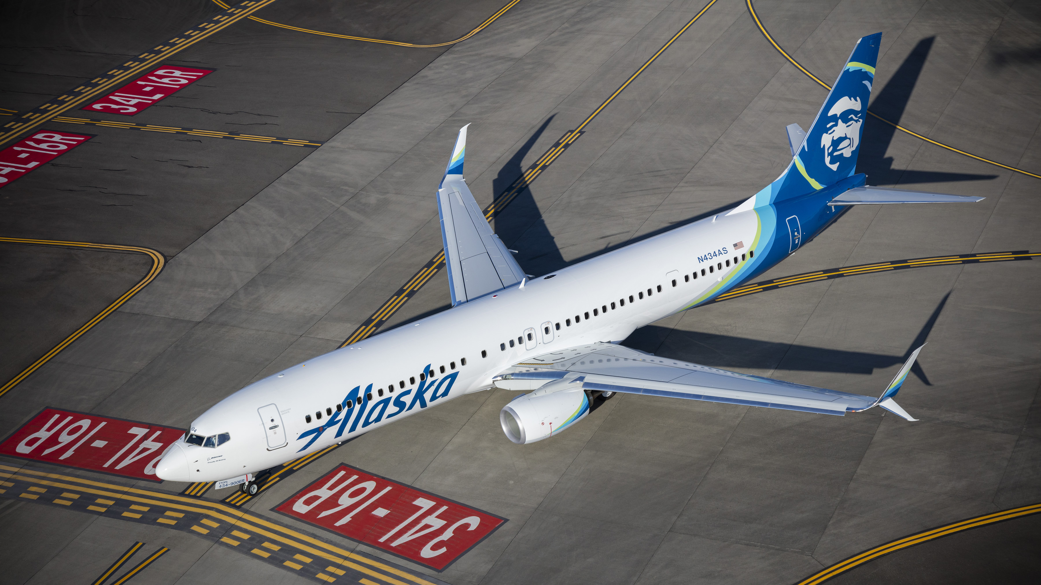 This is a photo of an Alaska Airlines jet taxiing on a runway.