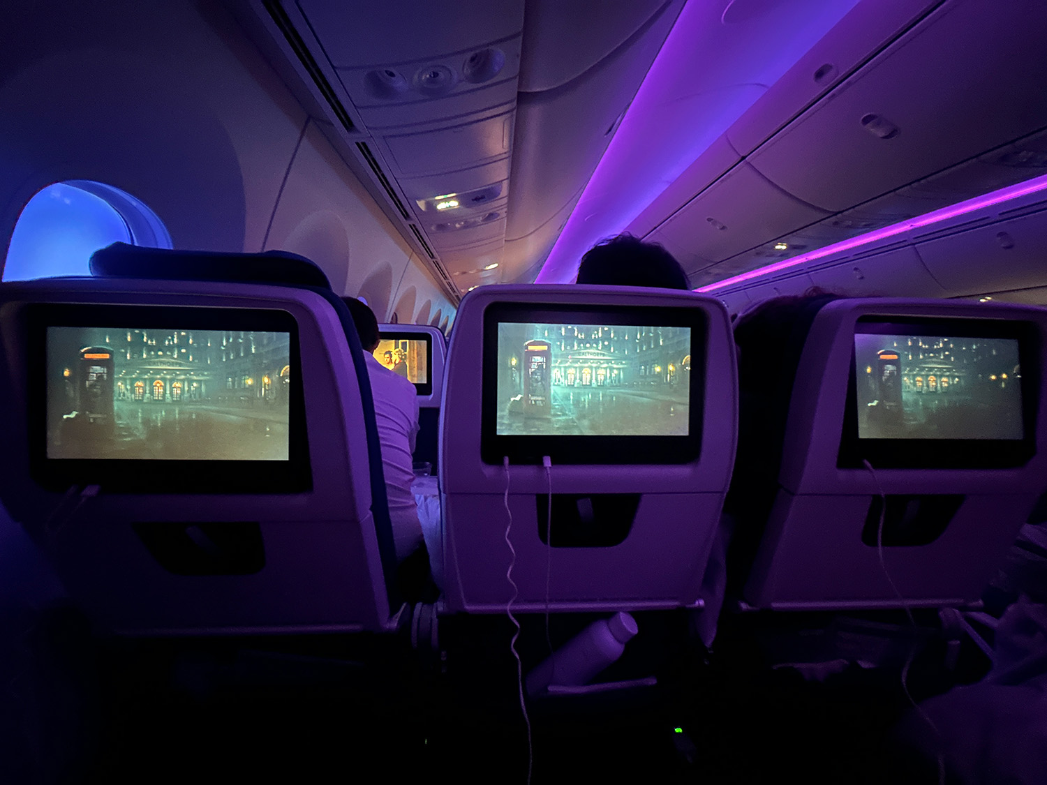 The author's picture of her and her seatmates' seatback screens, all playing the same movie.
