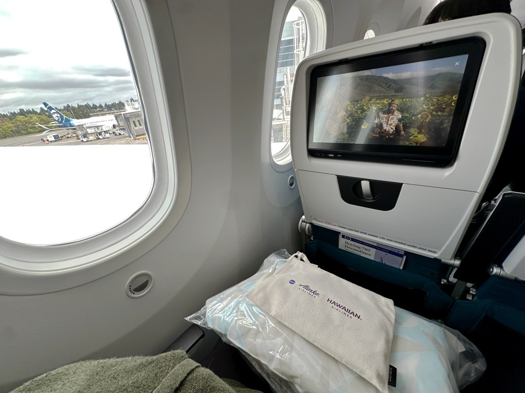 The author's photo of her seat while in Extra Comfort, with an Alaska Airlines tail window shot.