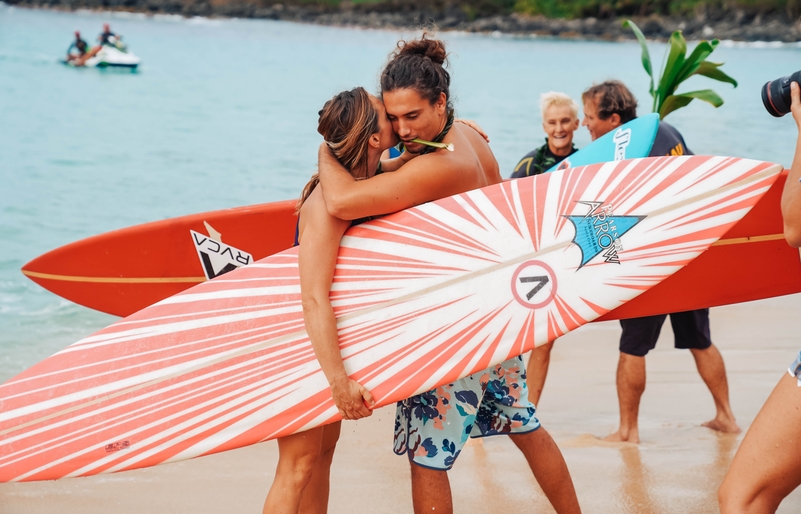 The Eddie Aikau Big Wave Invitational invitees embrace one another on the shoreline of a calm Waimea Bay prior to a group paddle-out ceremony. Eddie_Opening_Ceremony_120519-23