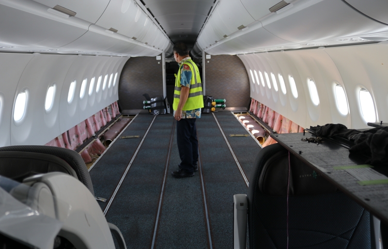 Yang inside a stripped-down Airbus A321neo cabin, which is being retrofitted with additional ventilation tubes beneath the floor. The modification is being done to a handful of A321neos and will optimize interior air temperature and circulation. IMG_3484