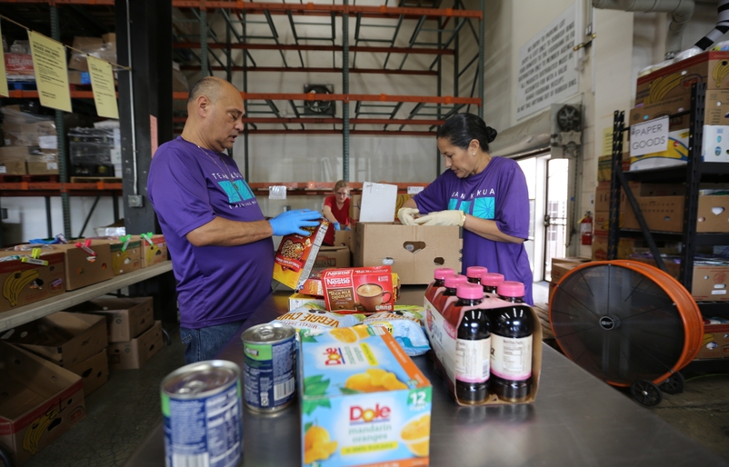 Hawaii Foodbank has expanded their safety rules, which now prioritizes social distancing and the use of personal protection equipment to protect volunteers and beneficiaries. MAIN PHOTO - Keoni Martin and Debbie Nakanelua Richards at HFB
