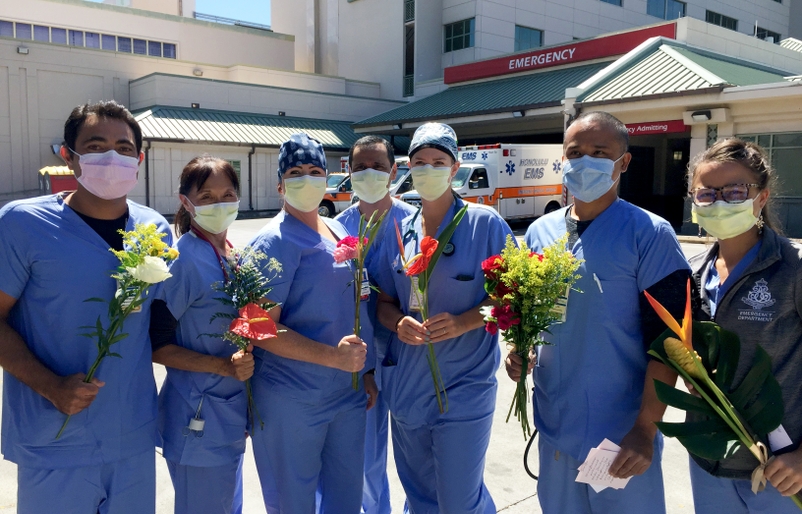 Emergency Department workers at The Queens Medical Center holding flowers that were donated to them as a mahalo. Queens