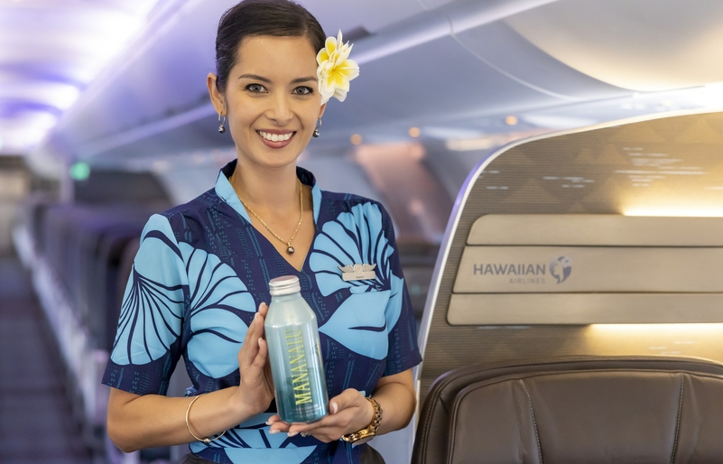 Flight attendant holding a Mananalu bottle