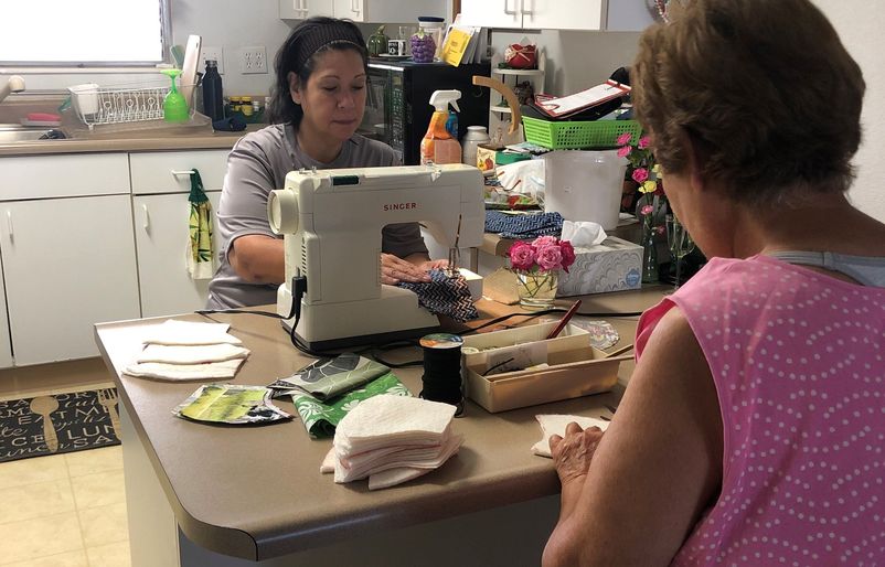 Vida and her mother sewing masks in the kitchen of her home. masks2